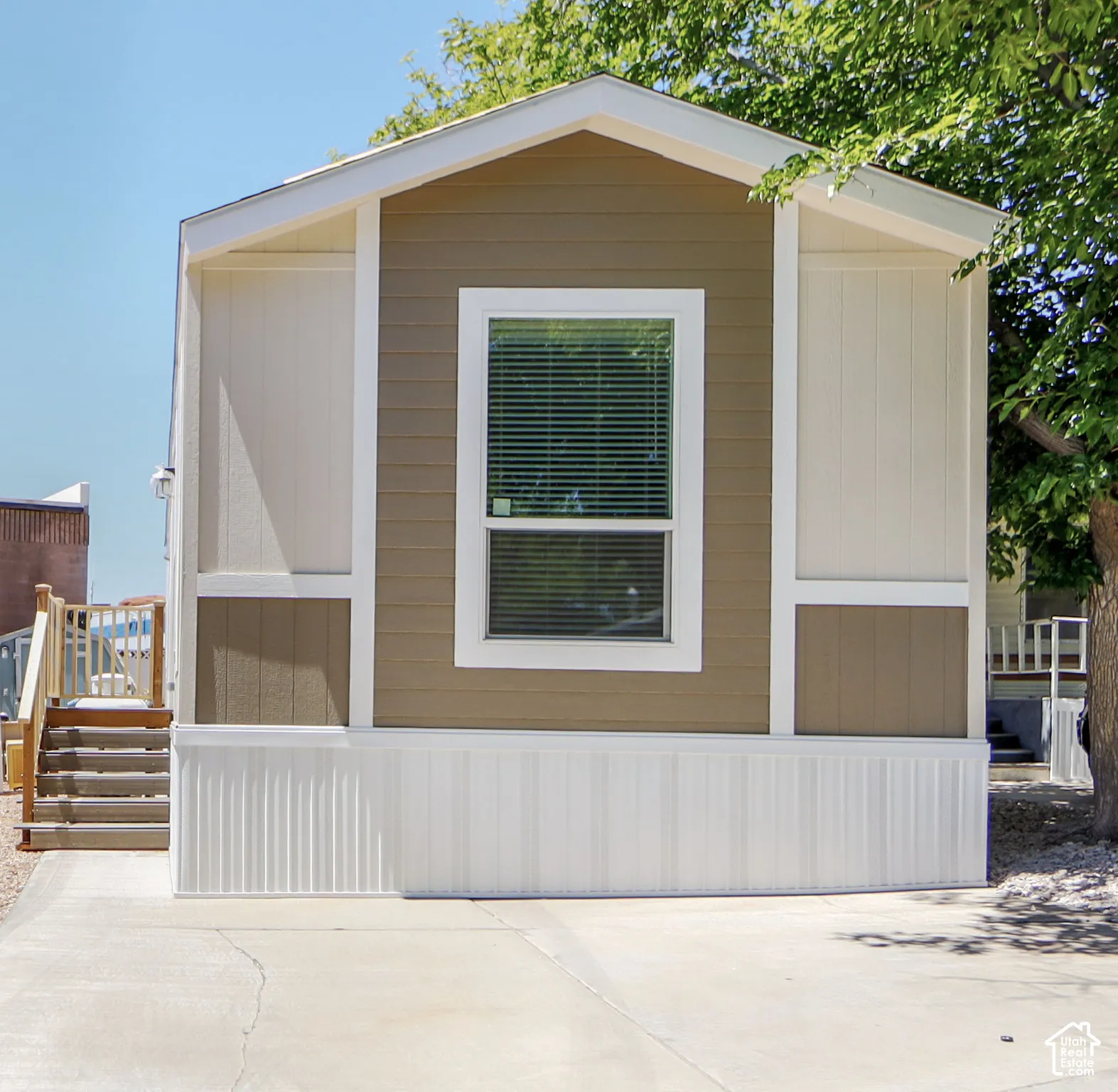 Exterior featuring horizontal siding, a prominent window with blinds, and white trim accents