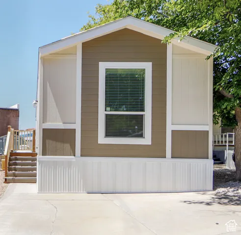 Exterior featuring horizontal siding, a prominent window with blinds, and white trim accents