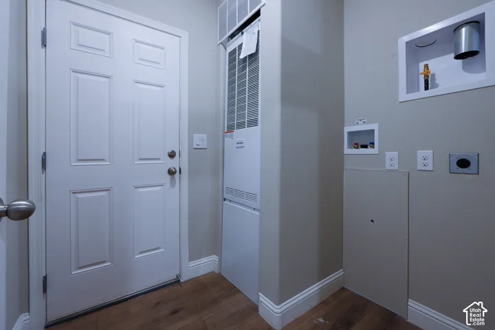 White paneled door with brushed nickel hardware, wood-finish flooring, and light gray wall paint