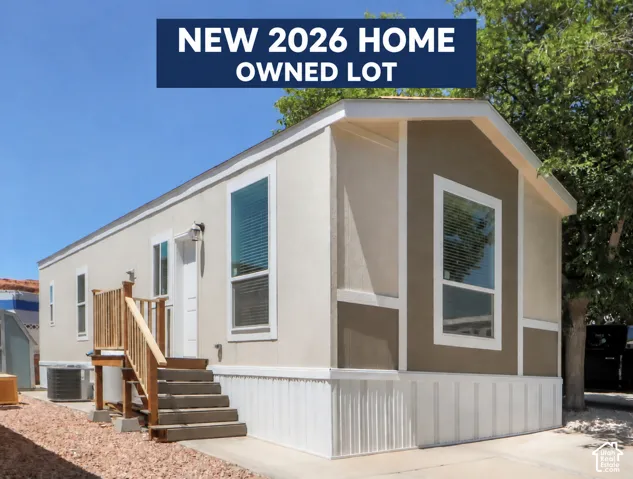 Contemporary manufactured home with a dual-tone exterior, white trim accents, and a front entry deck with steps