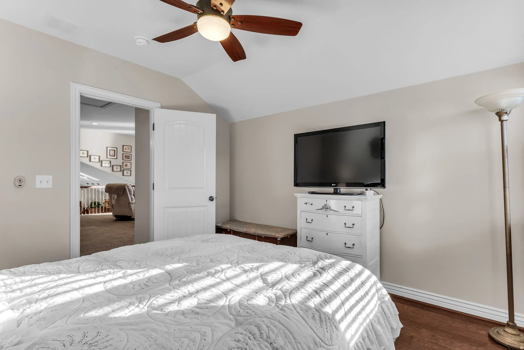 Hardwood-style flooring, ceiling fan with integrated lighting, and a neutral wall color