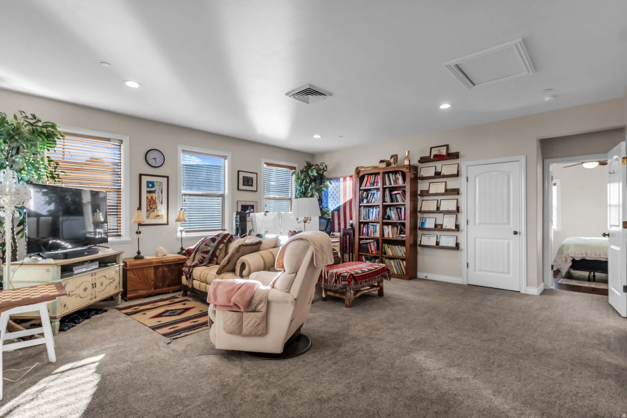 Recessed lighting, multiple windows with blinds, built-in shelving, paneled interior doors, and carpet flooring