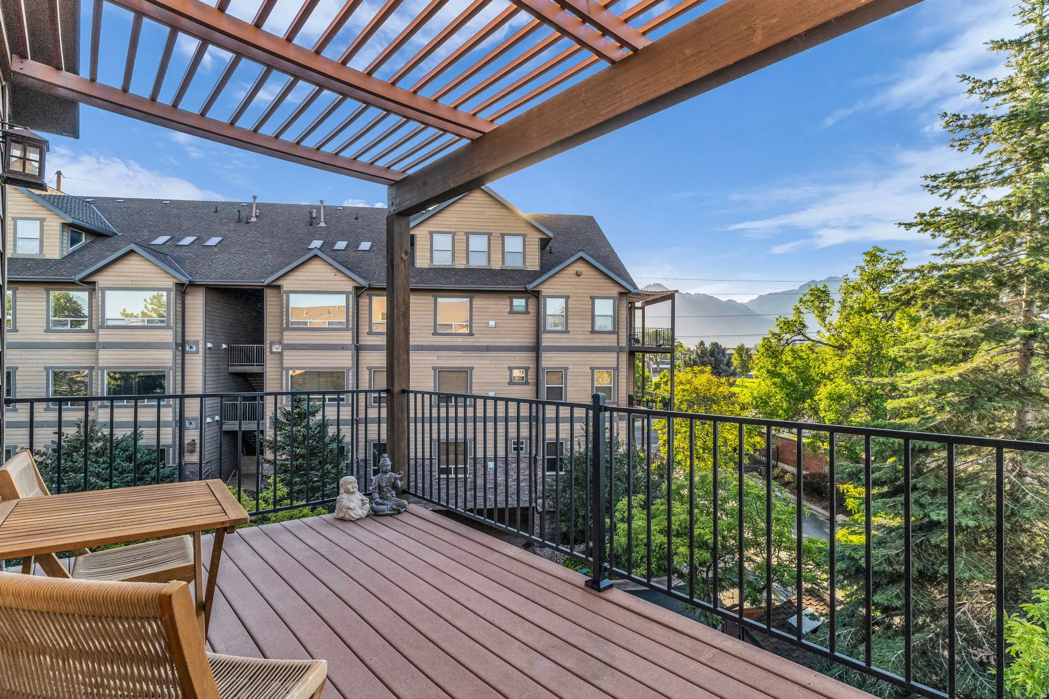 Composite decking with a black metal railing and a wood pergola, access from Main suite or hall.