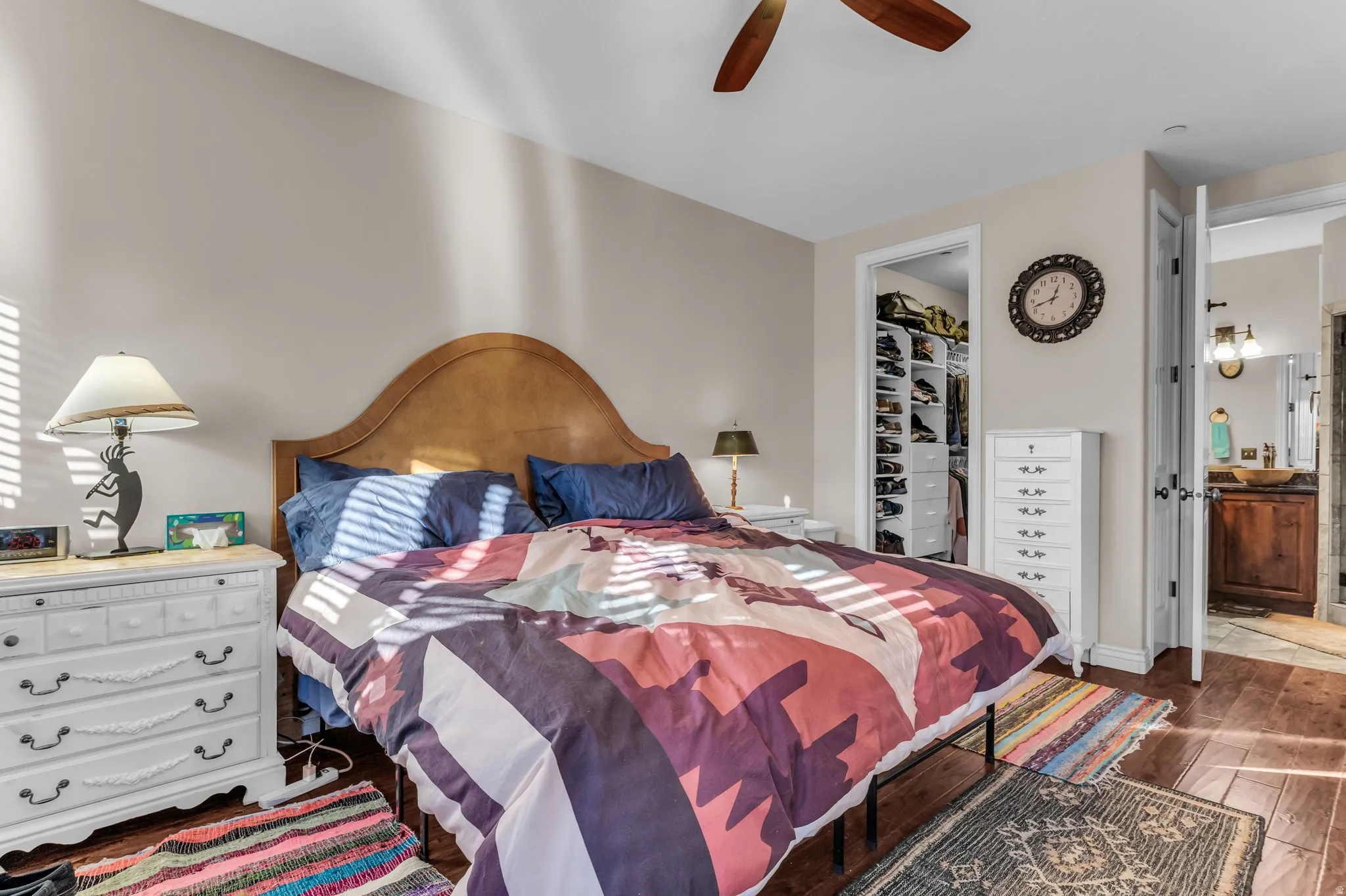 Hardwood-finish flooring, ceiling fan, and a walk-in closet with built-in shelving