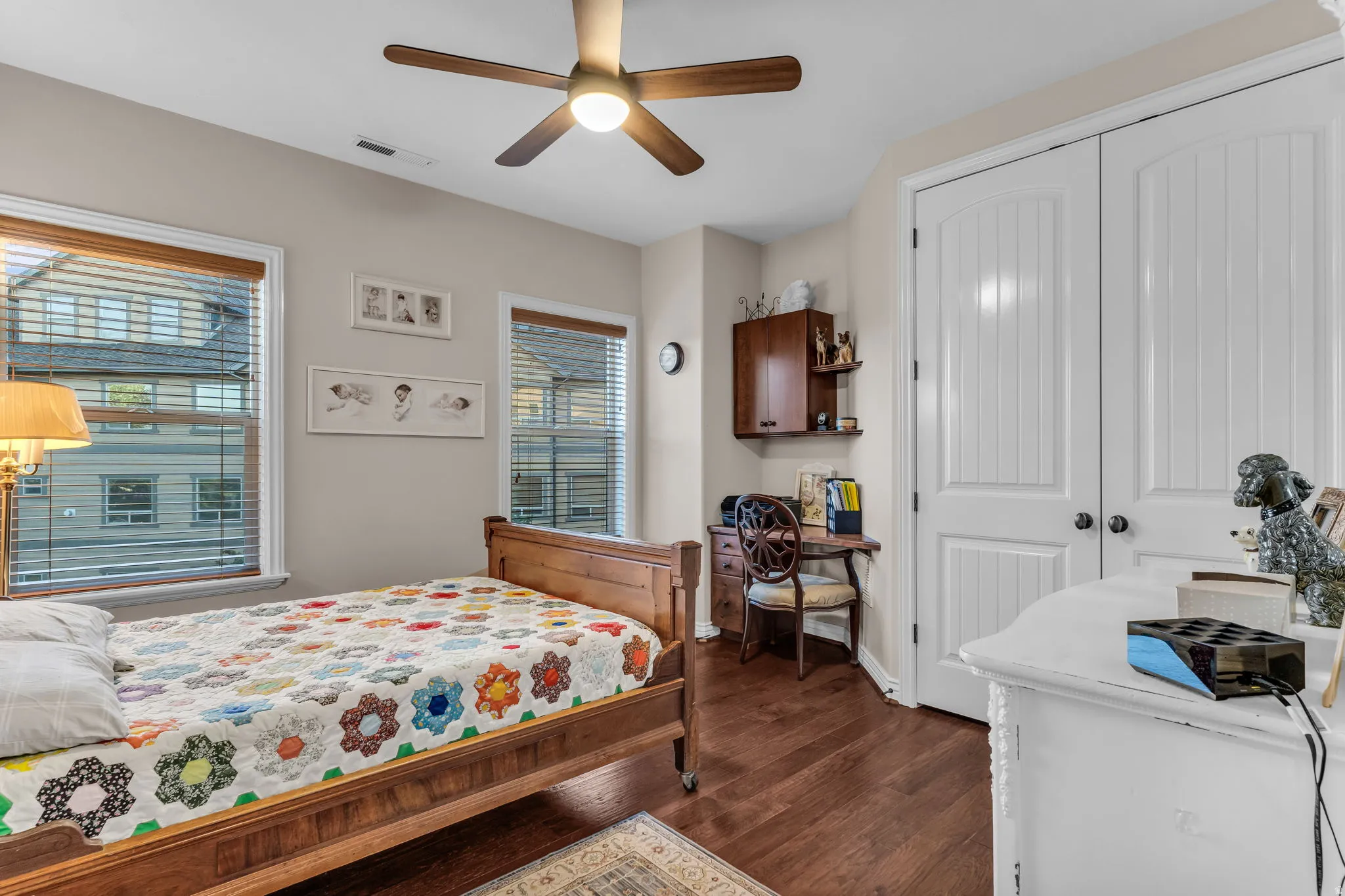 Hardwood flooring throughout, featuring a ceiling fan with light fixture, built-in cabinetry, and white paneled doors