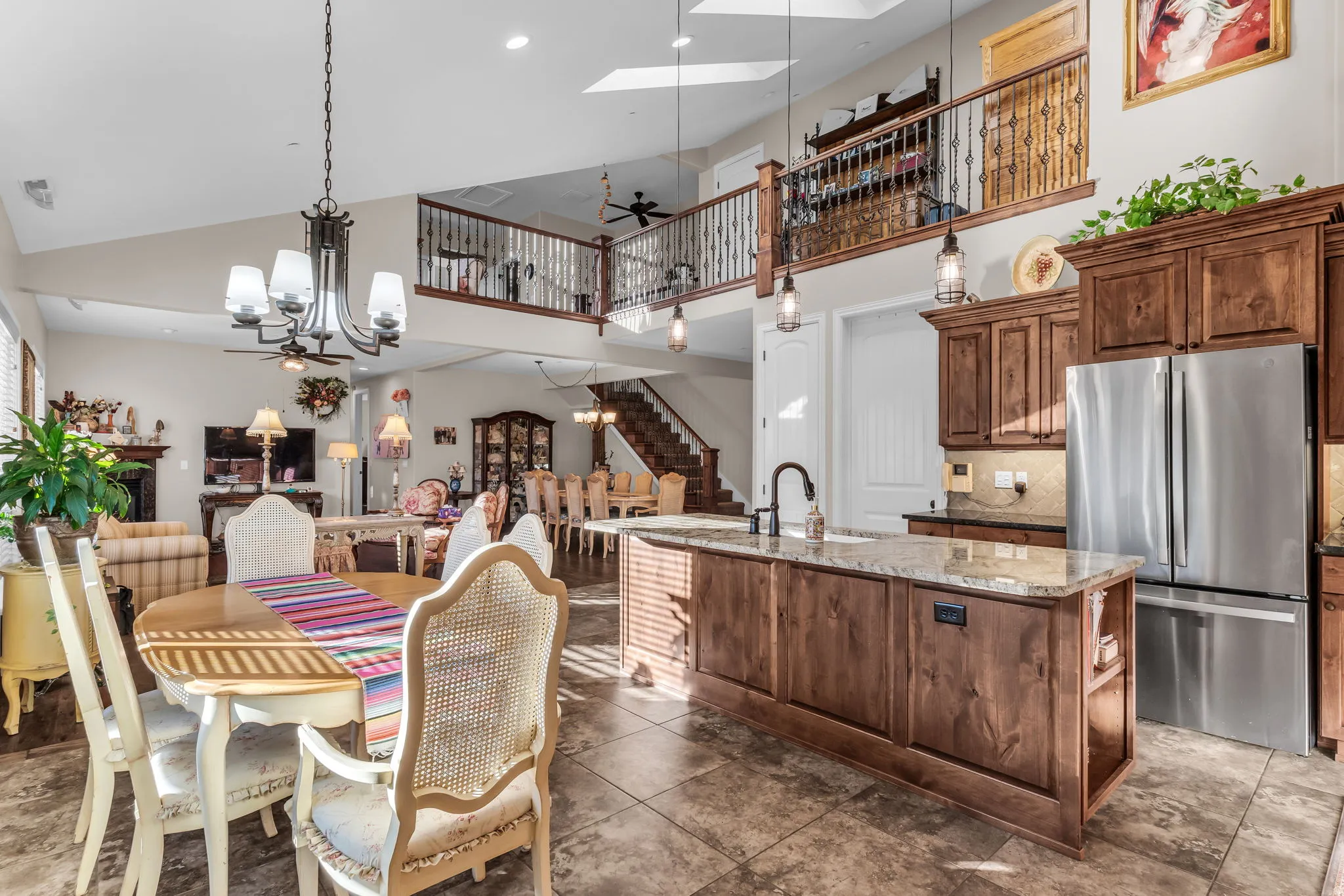 Gourmet kitchen featuring a large island with a sink, wood cabinetry, and stainless steel appliances