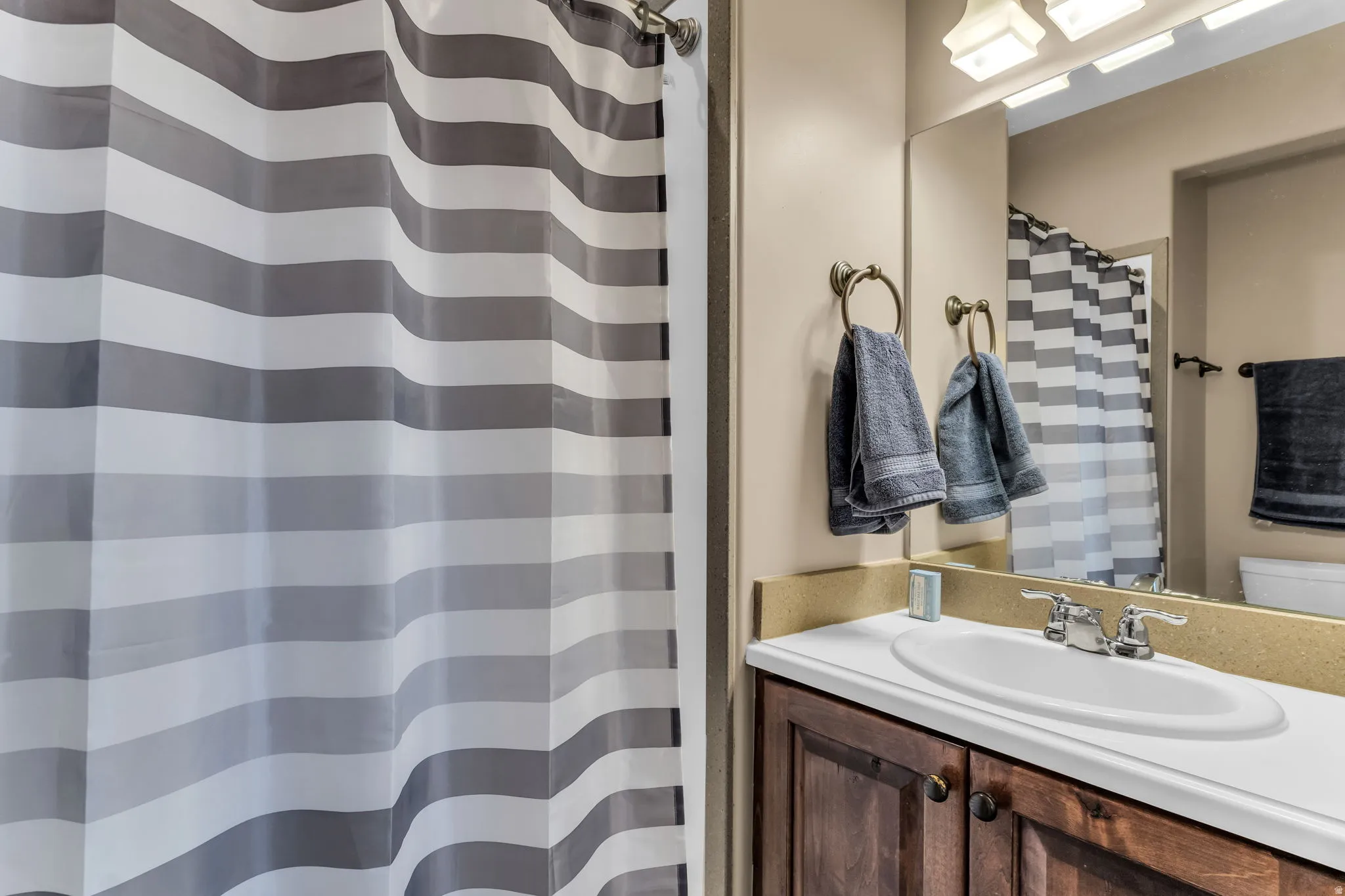 Integrated vanity with a single basin sink and dual-handle faucet