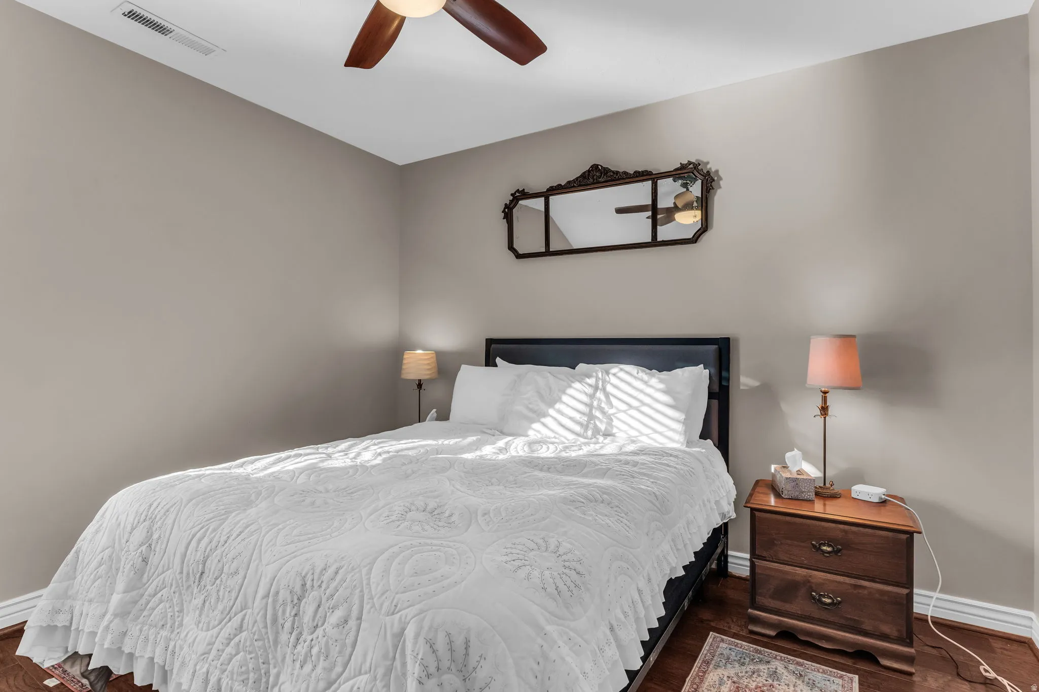 Wood-finish flooring with neutral wall tones and a ceiling-mounted fan