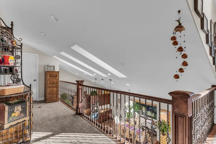 Vaulted ceilings with recessed lighting and skylights loft area