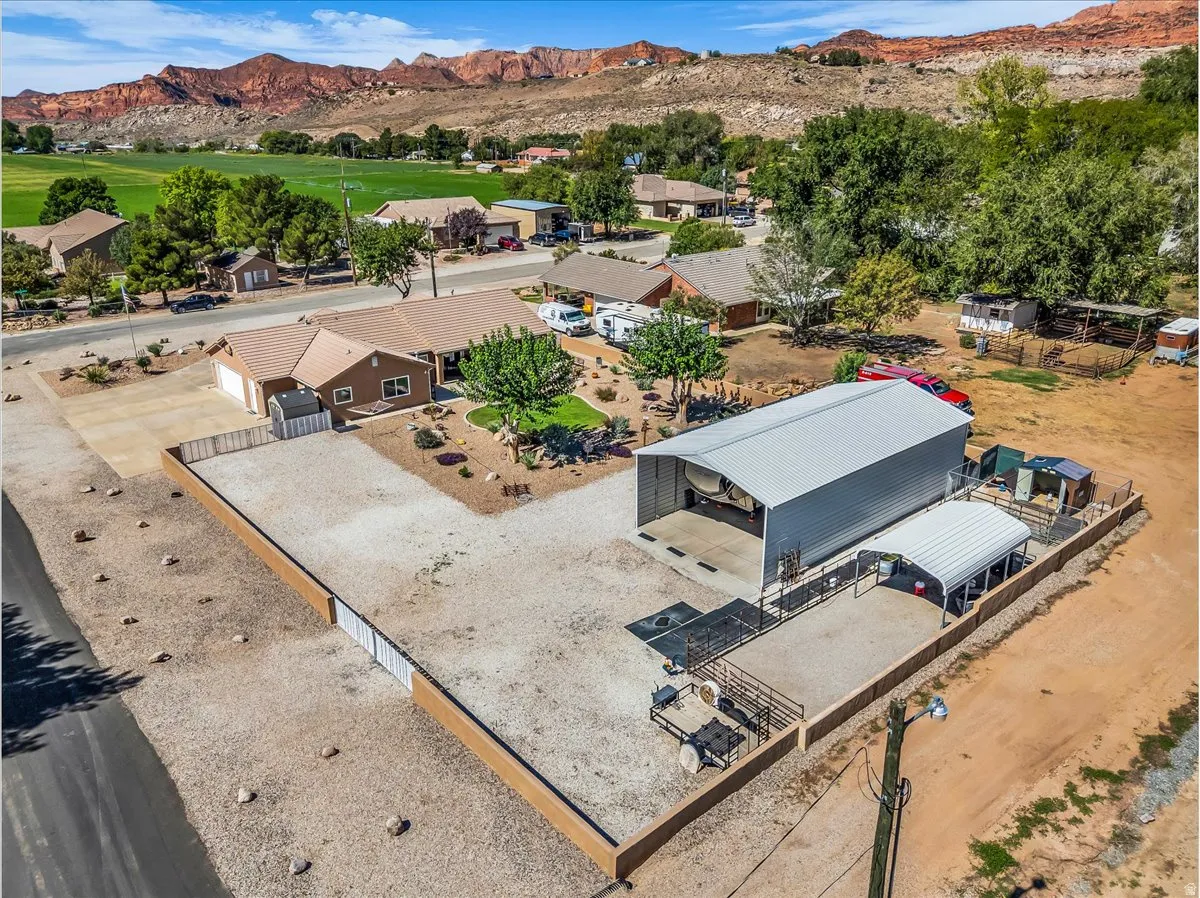 Single-story residence with a tan exterior, attached garage, and a gravel driveway