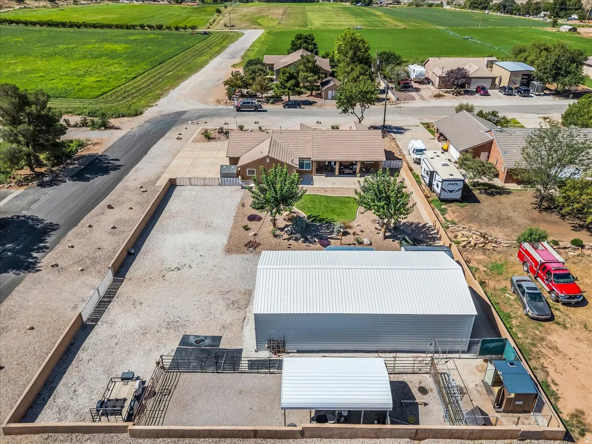 Extensive property featuring a detached metal-sided building, a covered structure, and fenced enclosures