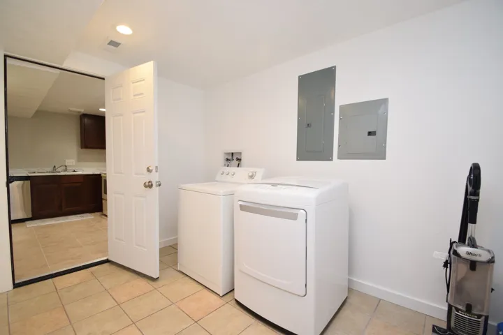 Utility room featuring tile flooring, recessed lighting, and a white paneled door