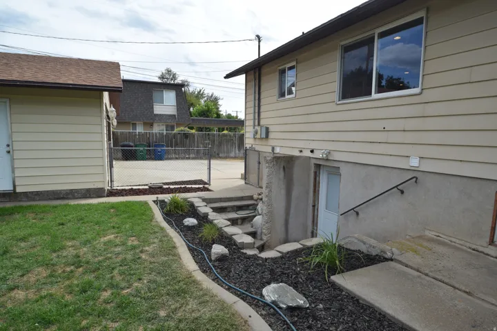 Exterior entry with a black metal handrail and concrete steps