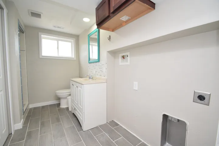 Full bathroom featuring a white vanity with a light-colored countertop, tiled flooring, and a shower enclosure