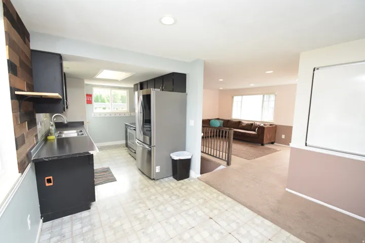 Kitchen featuring black cabinetry, stainless steel appliances, and a skylight
