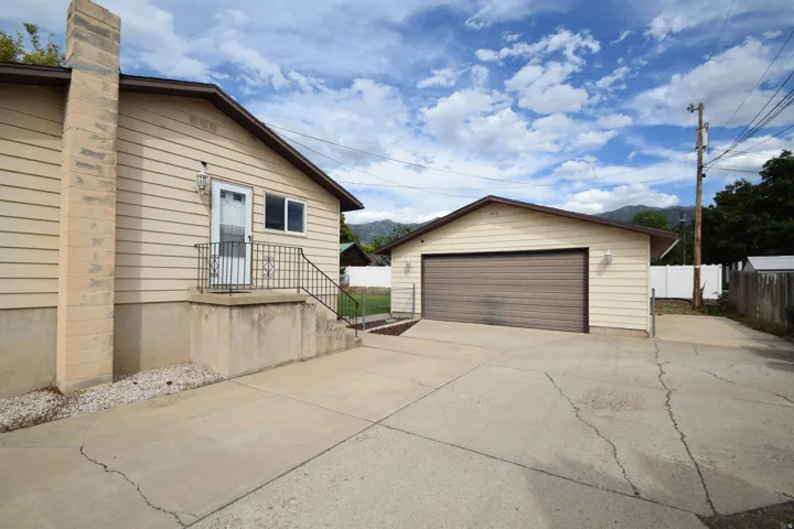 Detached garage, concrete driveway, and exterior siding