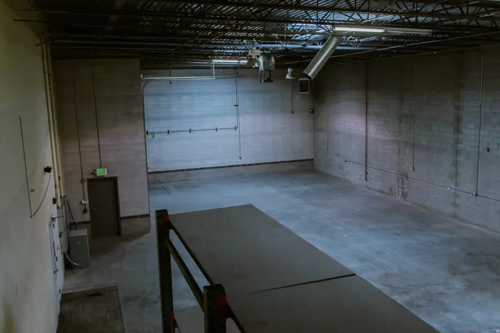 Spacious interior with exposed ceiling trusses, concrete block walls, and a finished concrete floor