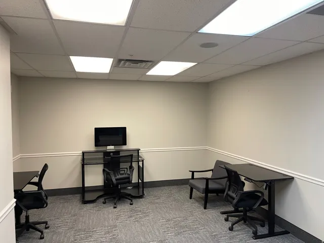 Recessed ceiling lighting, drop ceiling, neutral wall paint, crown molding, and carpet flooring