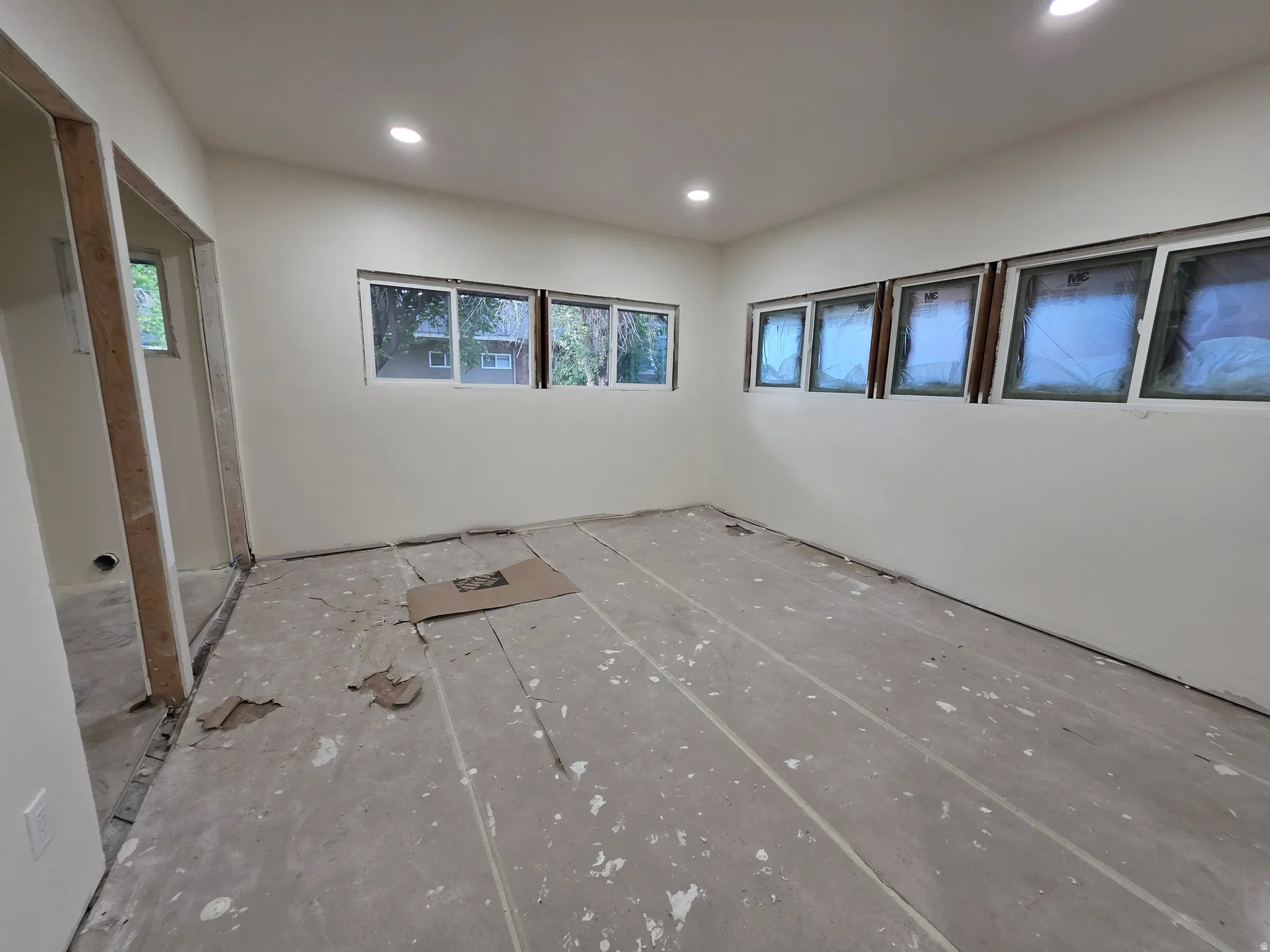 Recessed lighting, multiple windows, and a neutral wall color define this space