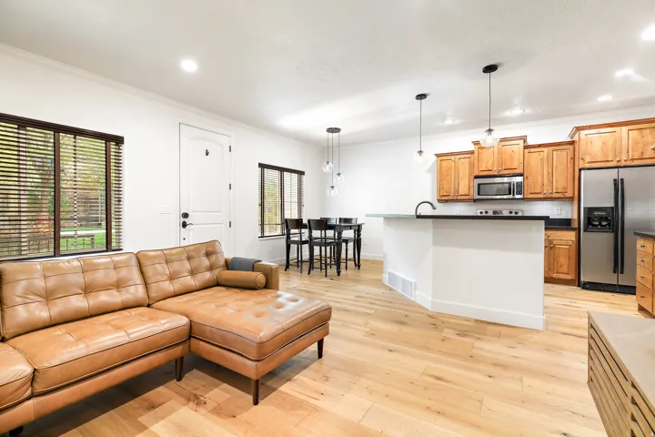 Open-concept living area featuring wood-finish flooring, recessed lighting, and ample natural light through multiple windows