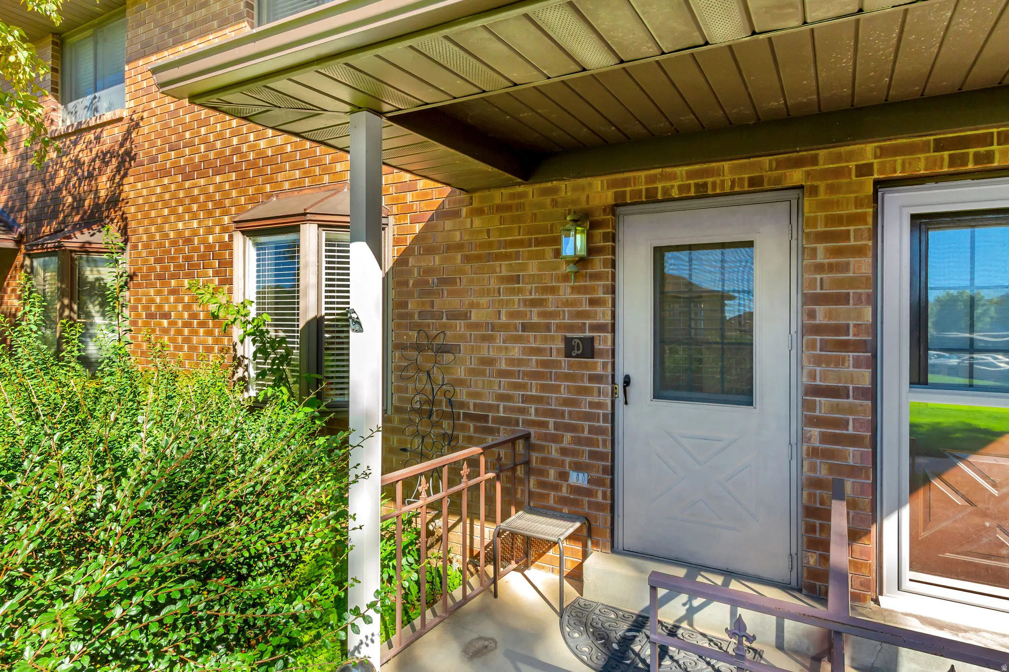 Brick exterior with a covered entry, decorative bay window, and a white storm door