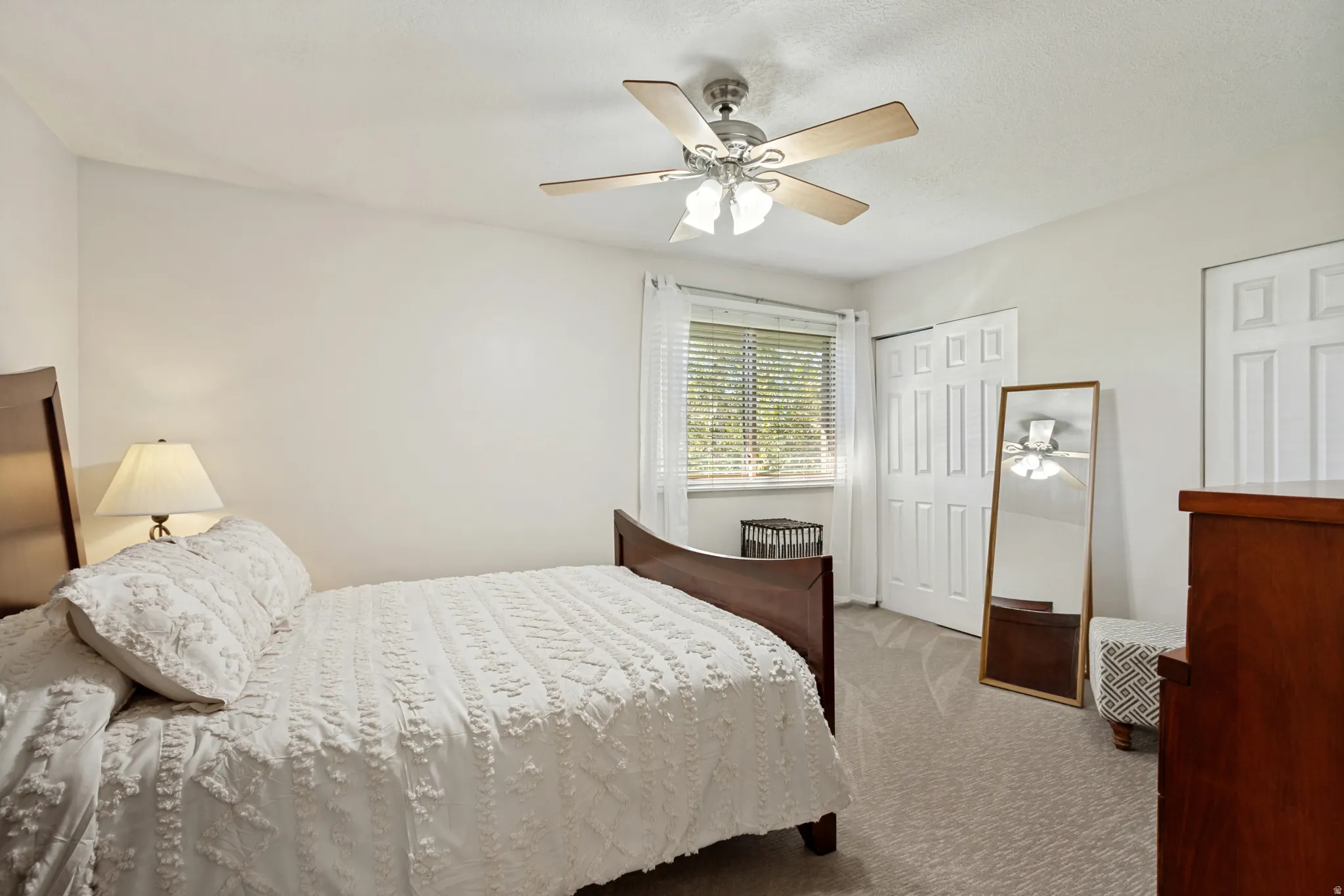 Carpeted flooring, ceiling fan with integrated lighting, window with blinds, and white panel doors