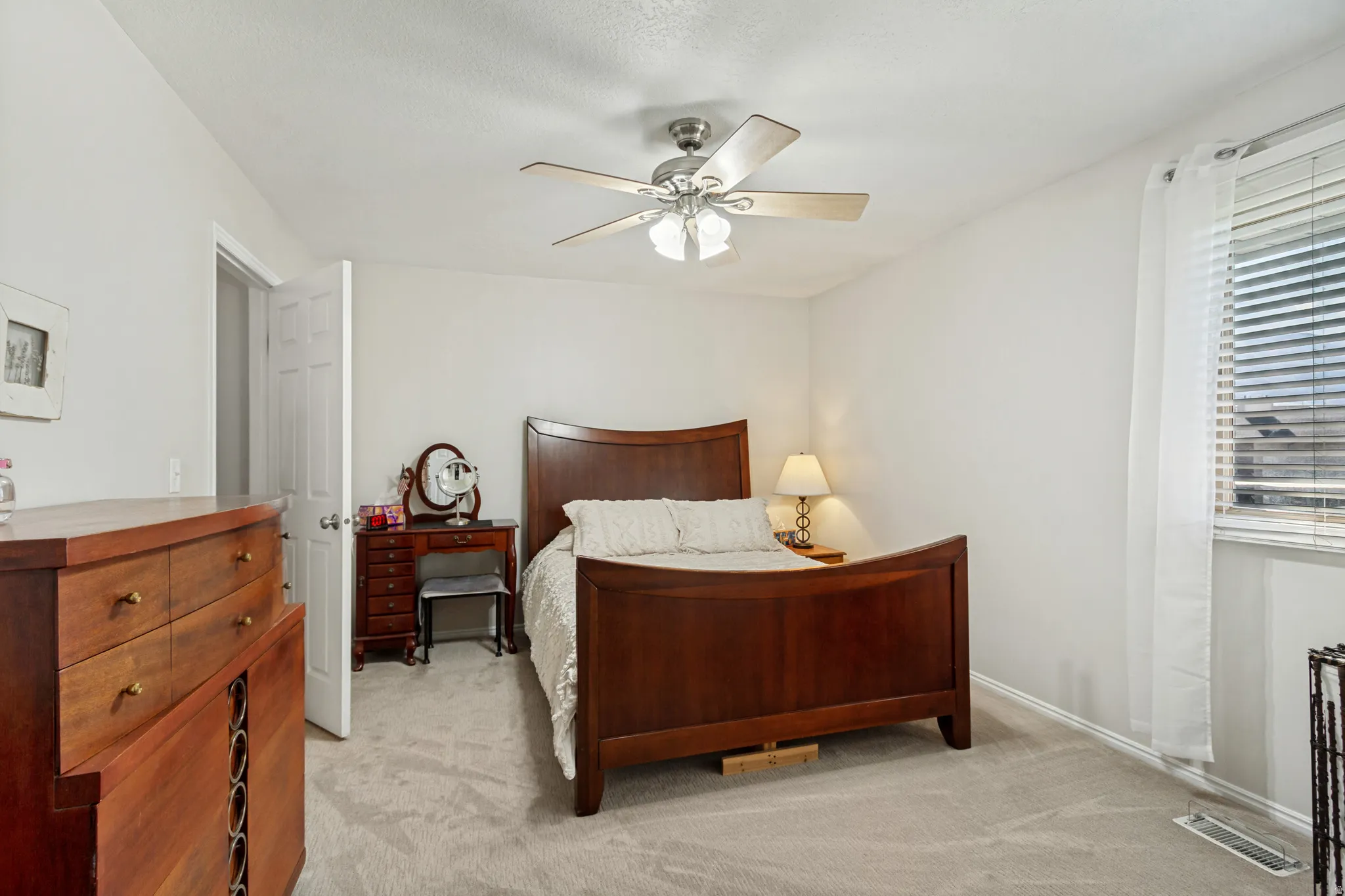 Carpeted flooring, recessed window with blinds, ceiling fan with integrated lighting, and a white paneled door