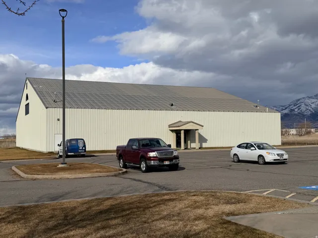 Metal-clad structure with a gabled roofline and an arched entry portico