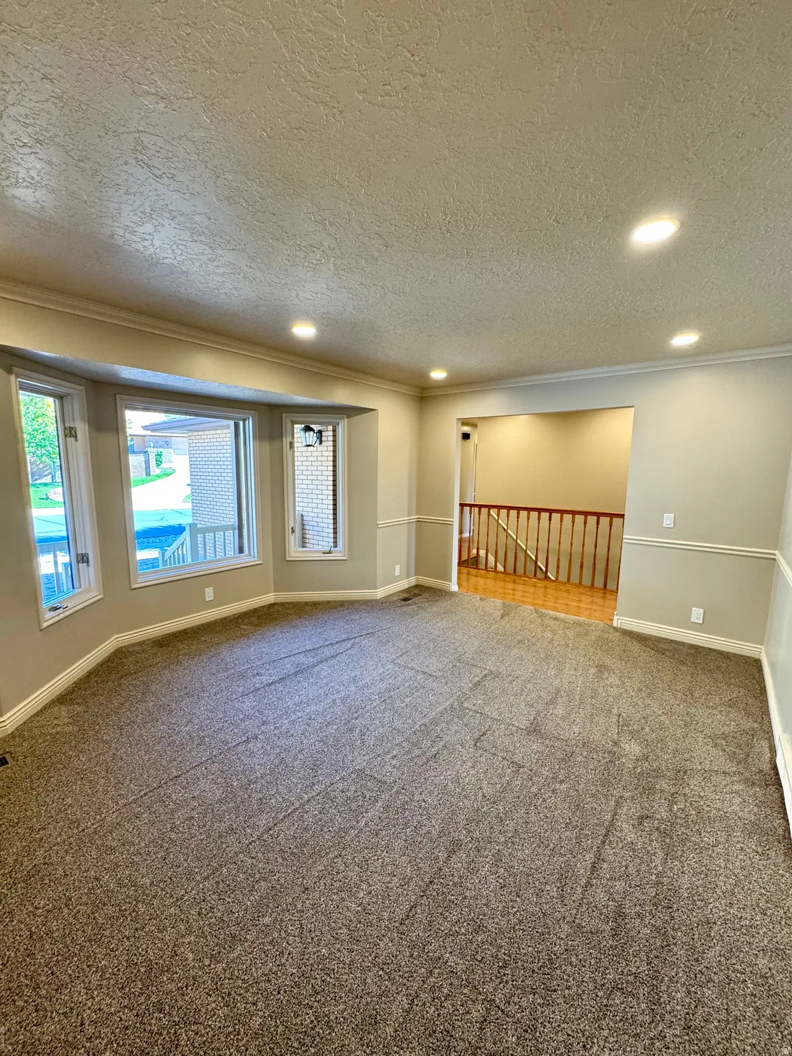 Spacious interior with neutral-toned walls and crown molding