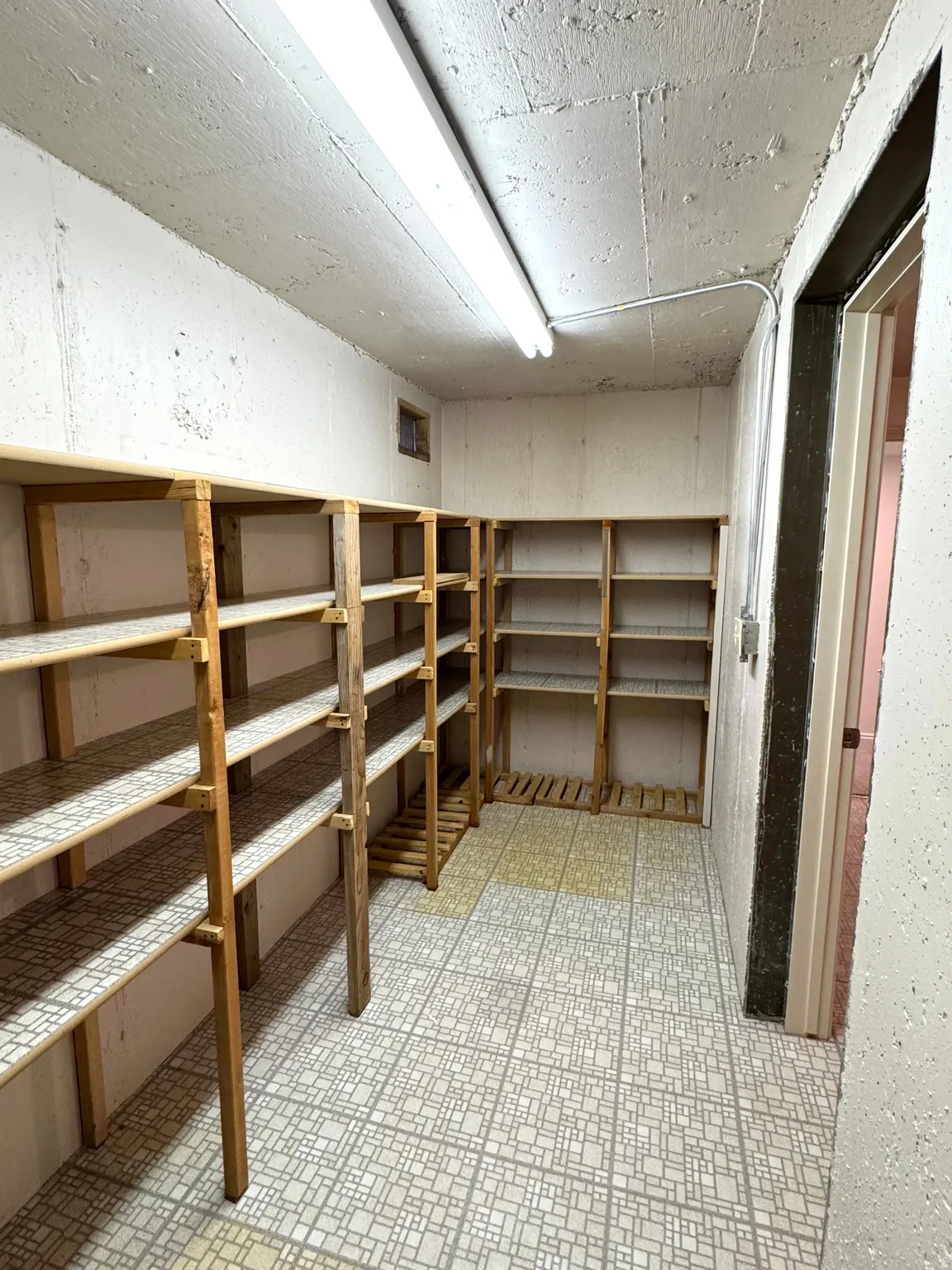 Extensive built-in shelving, durable tile-patterned flooring, and ample overhead lighting
