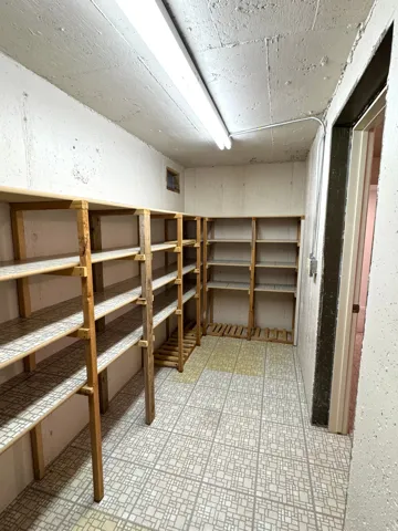 Extensive built-in shelving, durable tile-patterned flooring, and ample overhead lighting