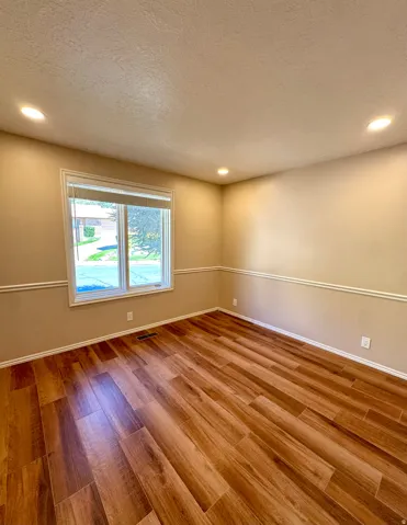 Recessed lighting illuminates wood-finish flooring