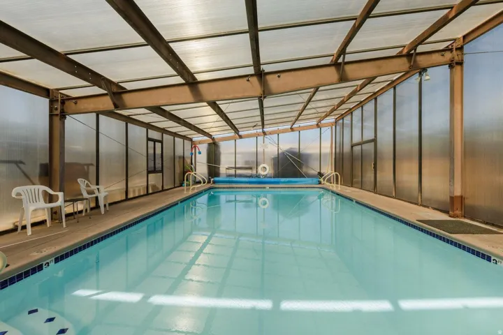 Indoor swimming pool with clear water, enclosed by a transparent panel structure