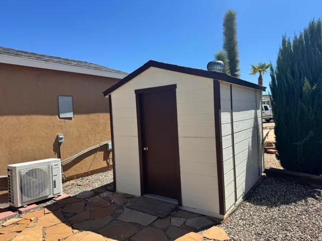 Detached shed with wood-panel siding and dark trim