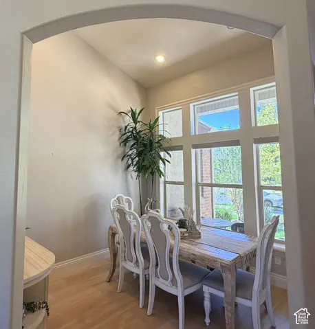 Arched entryway featuring an expansive multi-pane window, light laminate flooring, recessed lighting, and a built-in corner cabinet