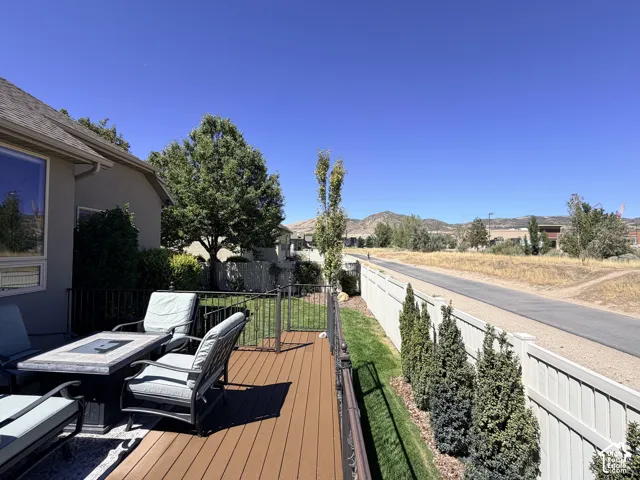 Wood-finish deck with a black metal railing and a partial privacy fence