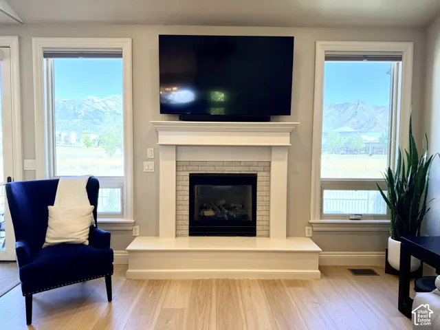 Fireplace with a tile surround and mantel, and two large windows with mountain scenery