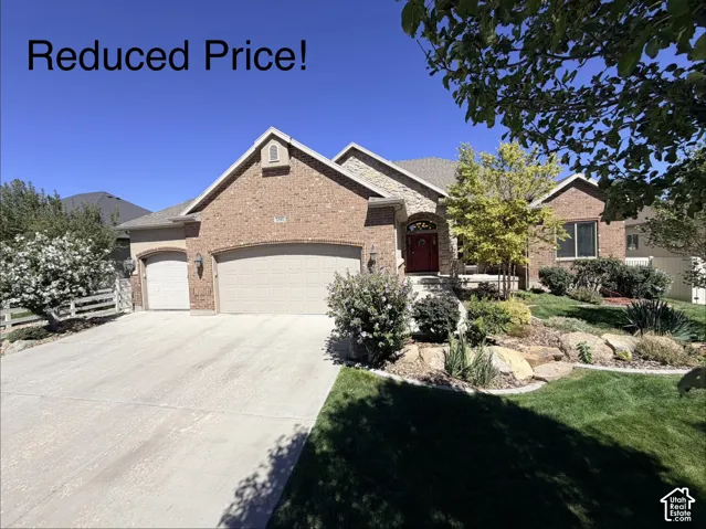 Brick exterior with stone accents, arched entry, two-car garage, and a concrete driveway