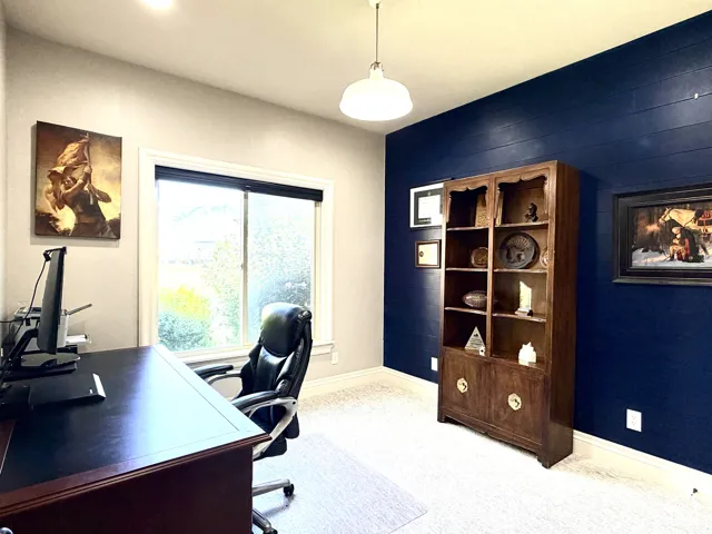 Carpeted room featuring a white-trimmed window, recessed lighting, and a prominent accent wall