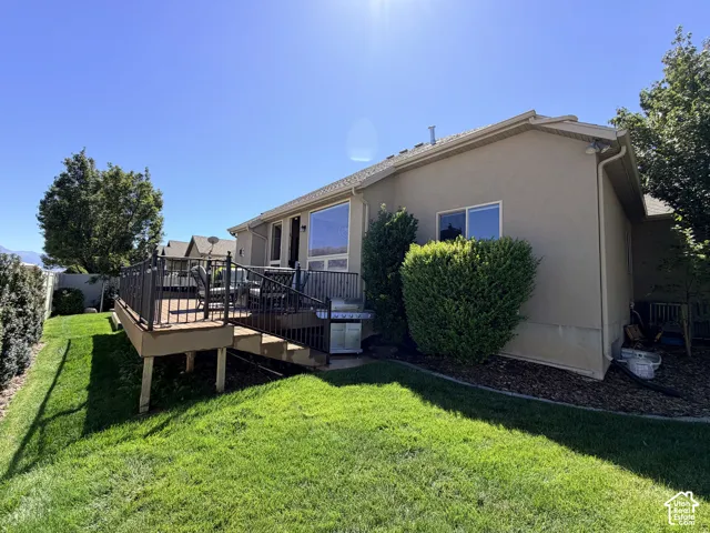 Spacious exterior deck with dark metal railings, wide steps, and a stucco exterior