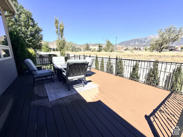 Expansive composite deck featuring a decorative metal railing and landscaped perimeter