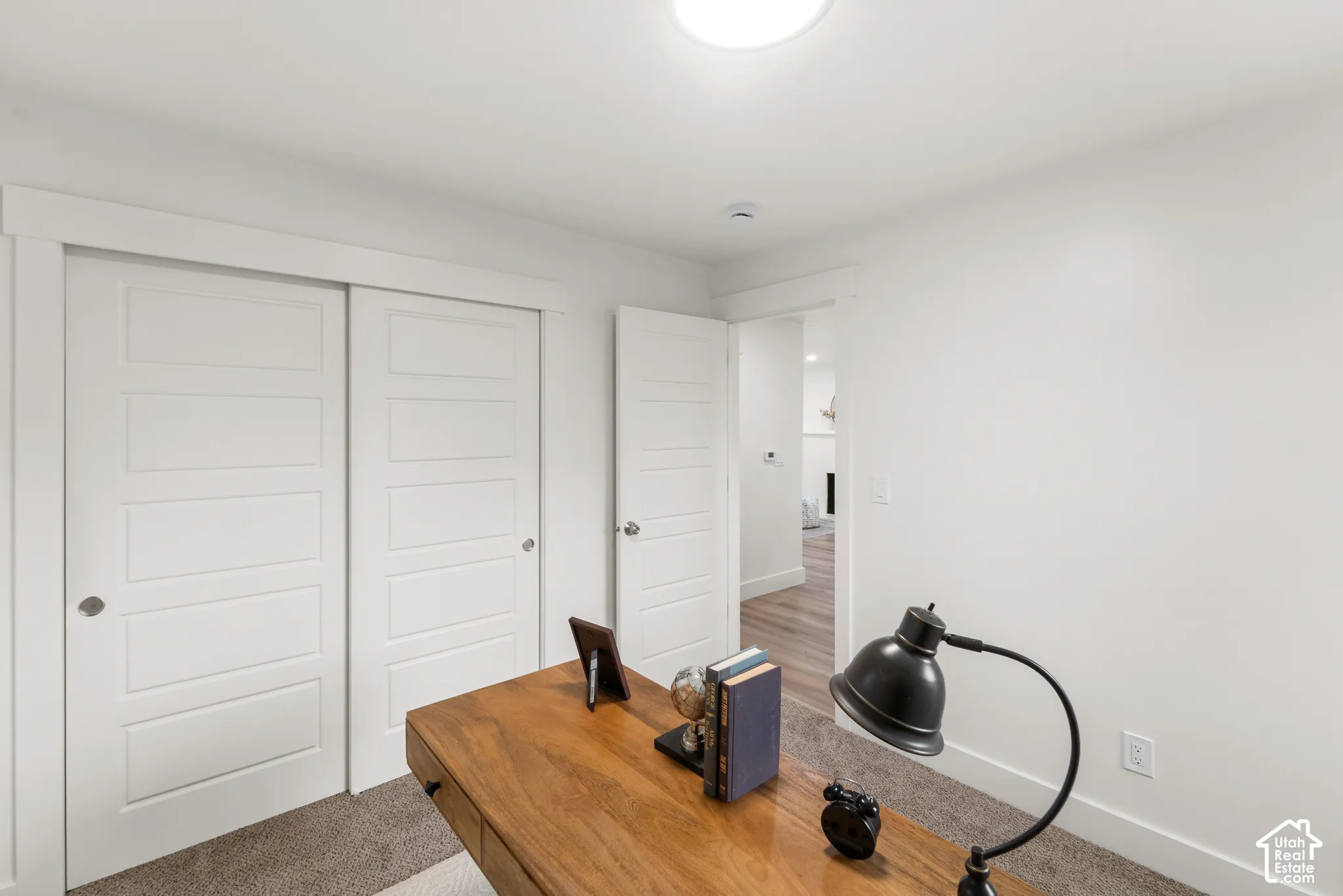 Recessed lighting, wood-finish flooring, white paneled doors, and neutral wall tones