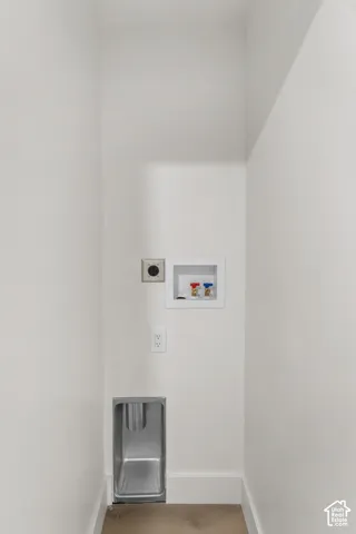 Laundry area with a stainless steel utility sink, electrical outlet, and washer hookups