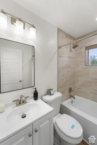 Vanity with an integrated sink and brushed nickel faucet, framed mirror, three-light fixture with frosted glass shades, tile-surround shower with a window, and a white bathtub