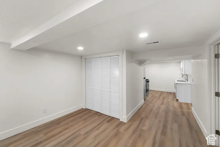 Wood-finish flooring, recessed lighting, and white louvered closet doors