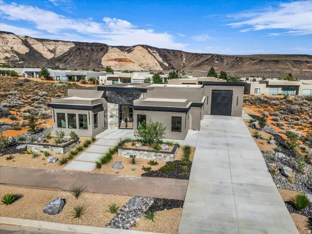 Modern exterior architecture featuring a prominent stone facade and a large concrete driveway