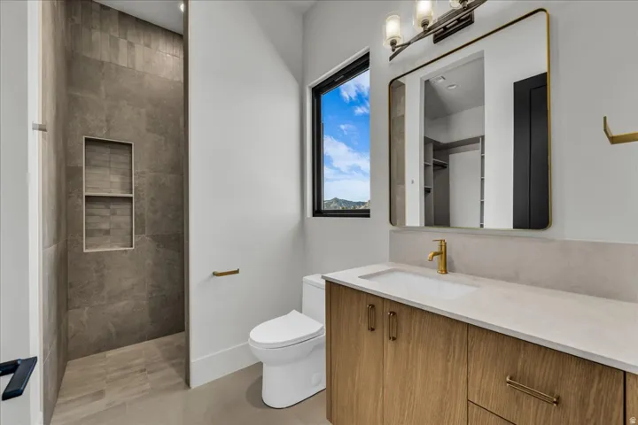Walk-in shower with tiled walls and recessed shelving