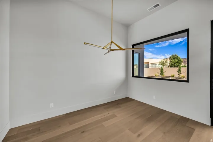 Recessed ceiling, wood-finish flooring, and a modern linear chandelier
