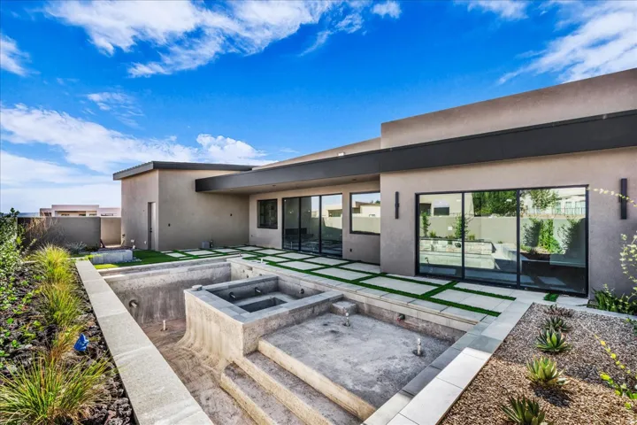 Modern exterior architecture with stucco finish, a concrete patio, and a dedicated pool and spa area