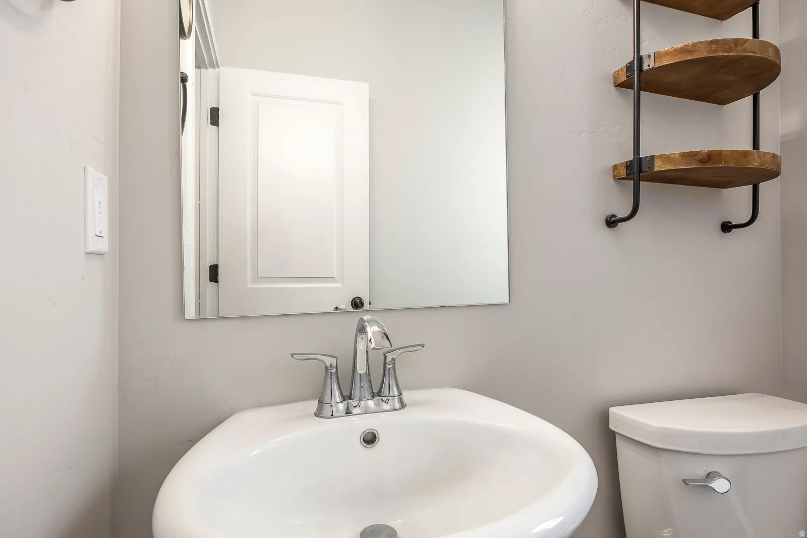 White pedestal sink with chrome faucet